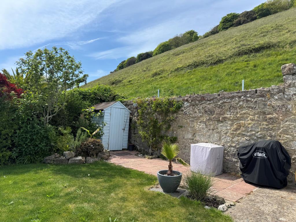 Lot: 142 - COTTAGE WITH SEA VIEWS FOR INVESTMENT OR OCCUPATION - A View of the Garden with St Boniface Down Behind